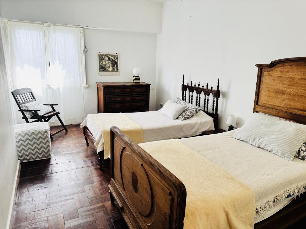 una camera con due letti e una sedia di Chalet Quintana a Mar del Plata