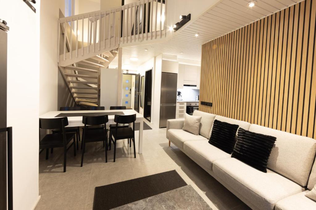 a living room with a couch and a table with chairs at Ski Center Alpine Houses A6 in Levi