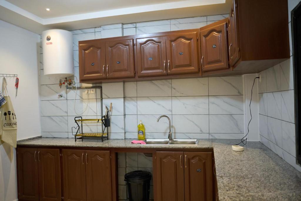 una cucina con mobili in legno e un lavello di Mandys Guest House a Yaoundé