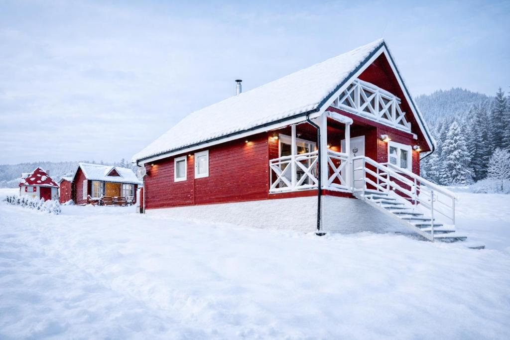 een rode hut in de sneeuw, bedekt met sneeuw bij Arctic House in Dolný Kubín