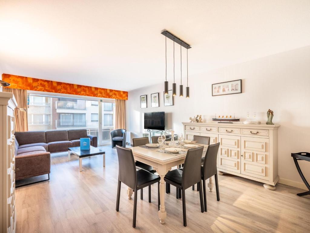 a dining room and living room with a table and chairs at Premieres Loges in Sint-Idesbald