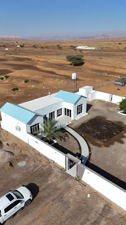 uma casa branca com um carro estacionado em frente dela em RIVA CHALEt em Badīyah