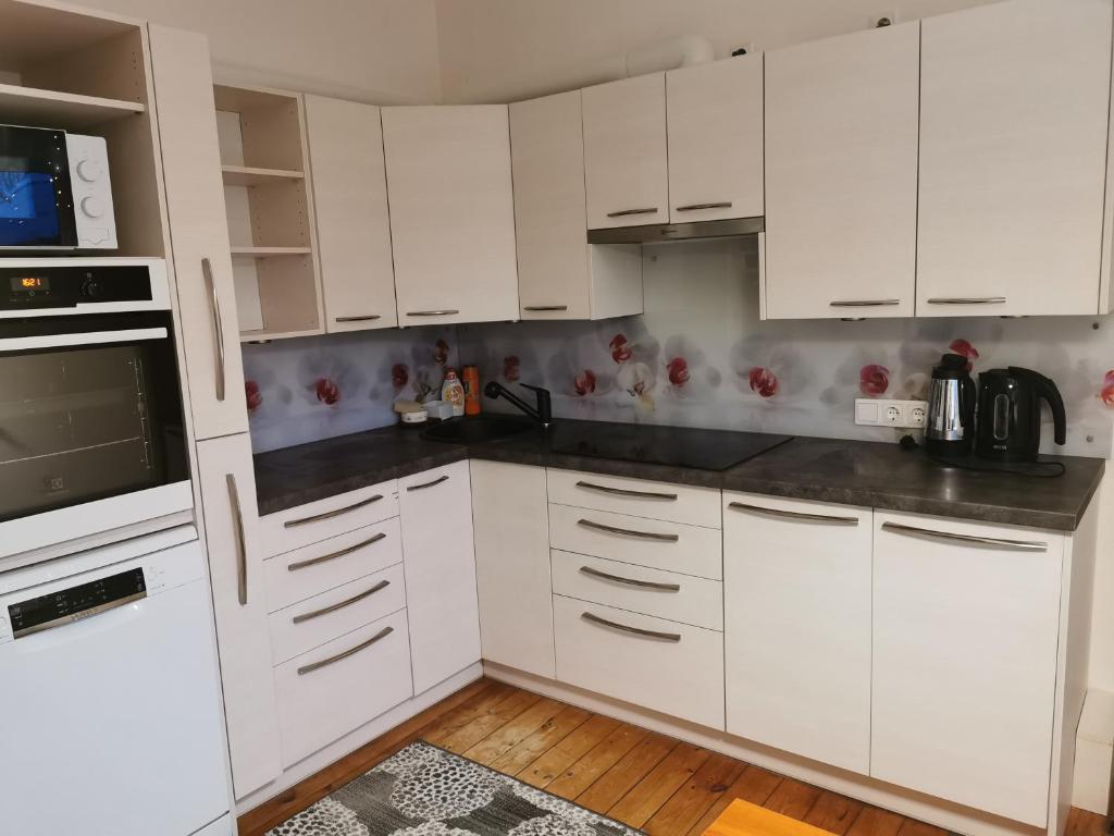 een witte keuken met witte kasten en een magnetron bij Jõe House in Valga