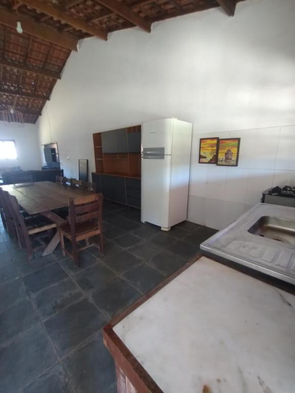 una cucina con un tavolo e un frigorifero bianco di Chácara Recanto Girassol a Biritiba-Mirim