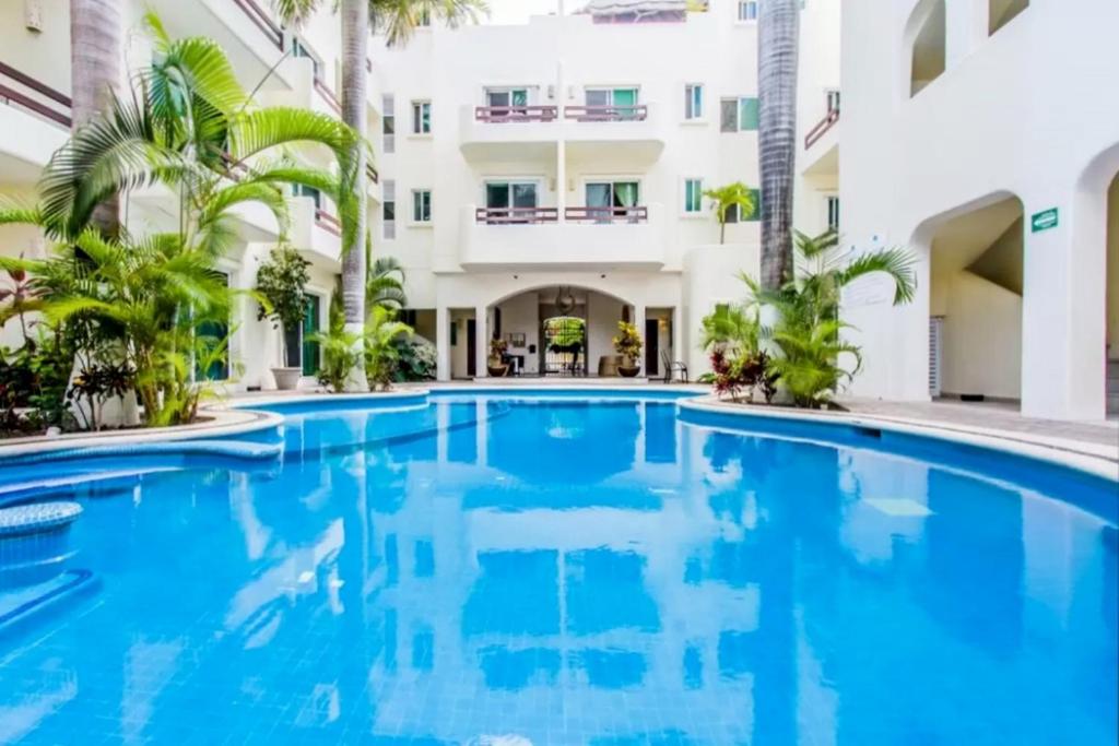 a swimming pool in front of a building at Playa Kaan Condominiums- Unit 22 in Playa del Carmen
