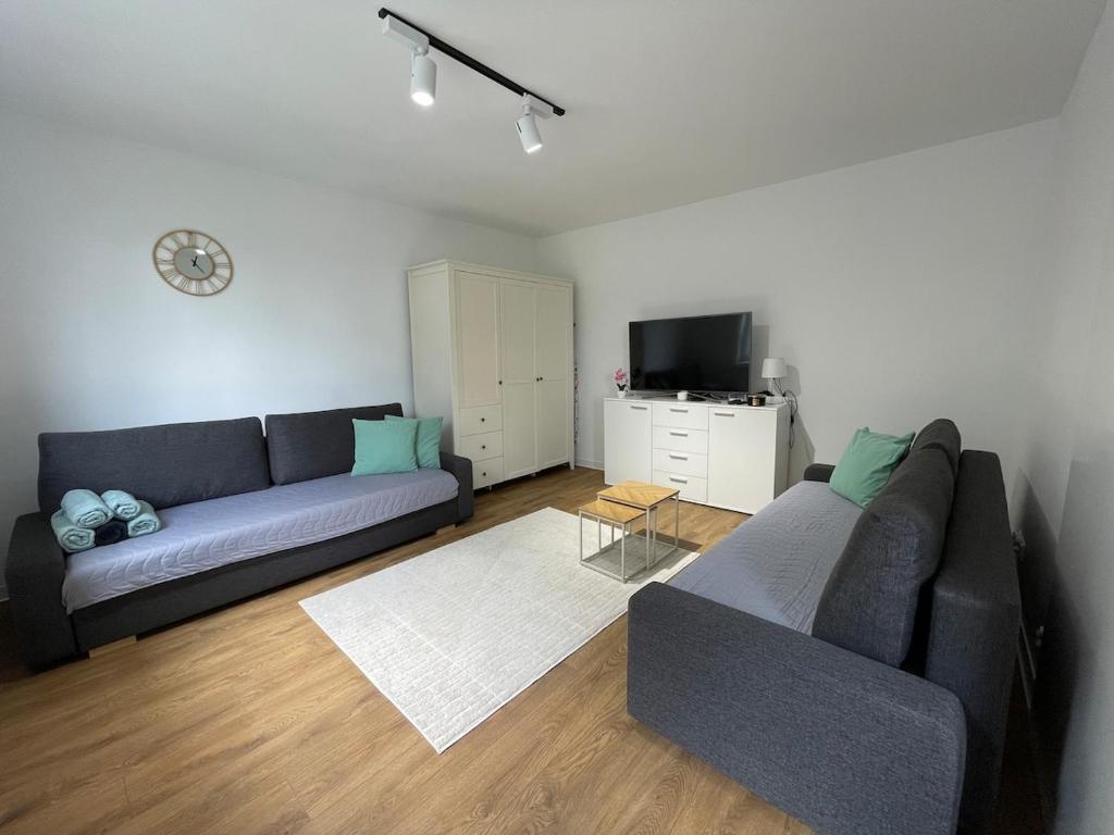 een woonkamer met een bank en een tv bij Zacisze Ludowa in Olecko