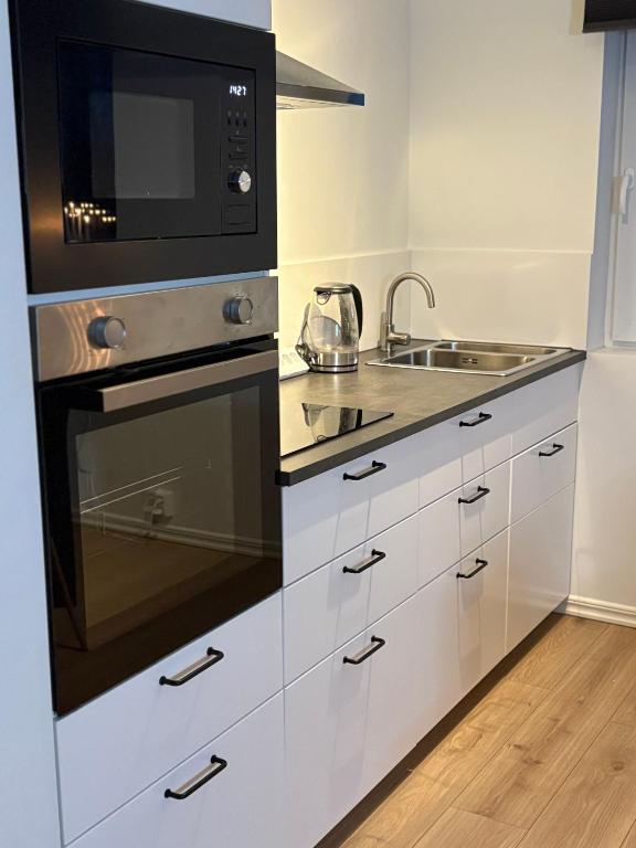 a kitchen with a stove and a microwave at High Coast Stay Floor 1 in Ramvik