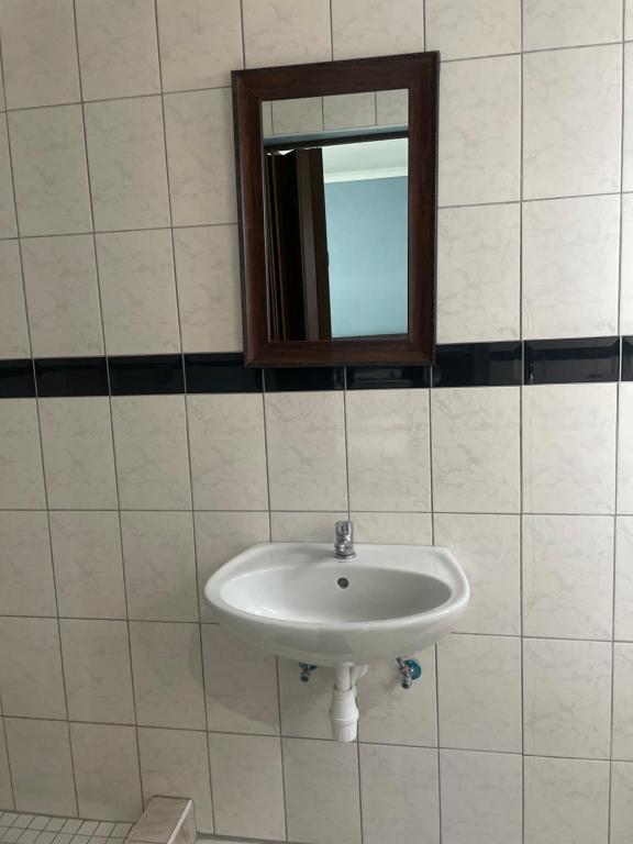 a white sink in a bathroom with a mirror at RT Guest House in Walvis Bay