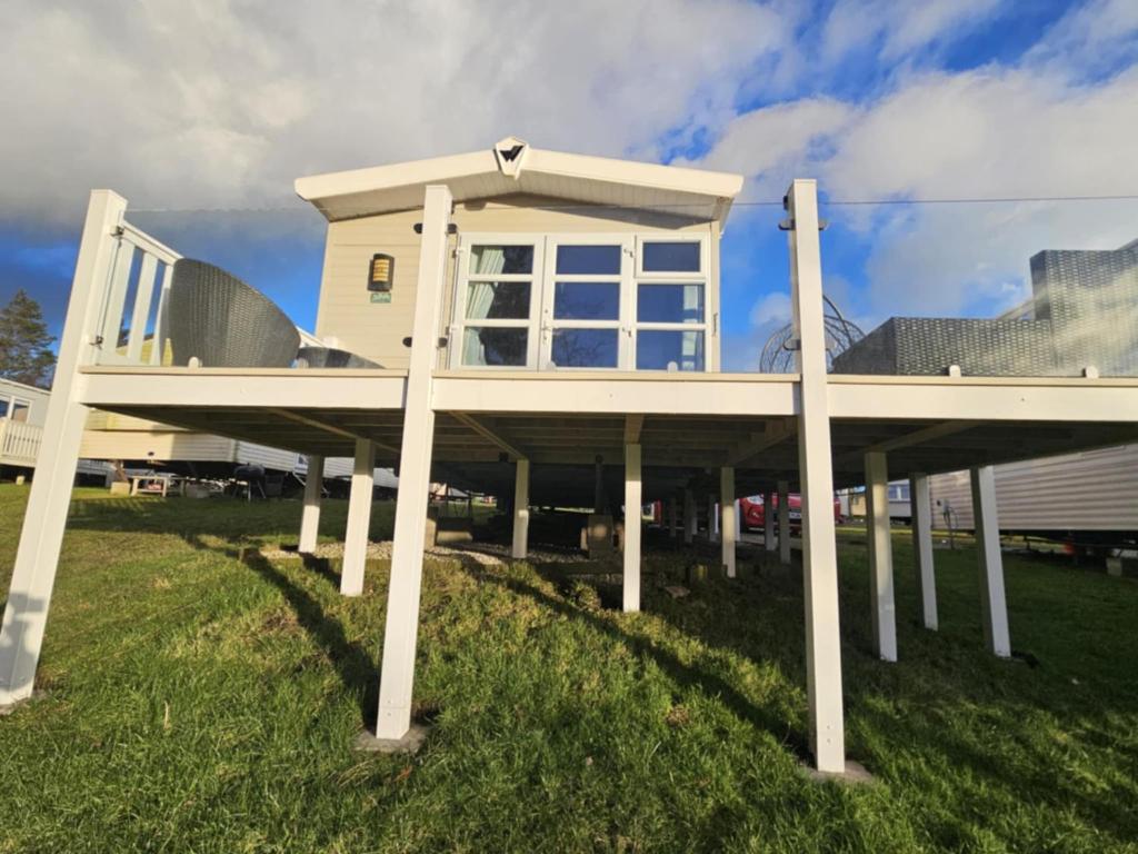 a house with white posts in the grass at The Suite in Tosside