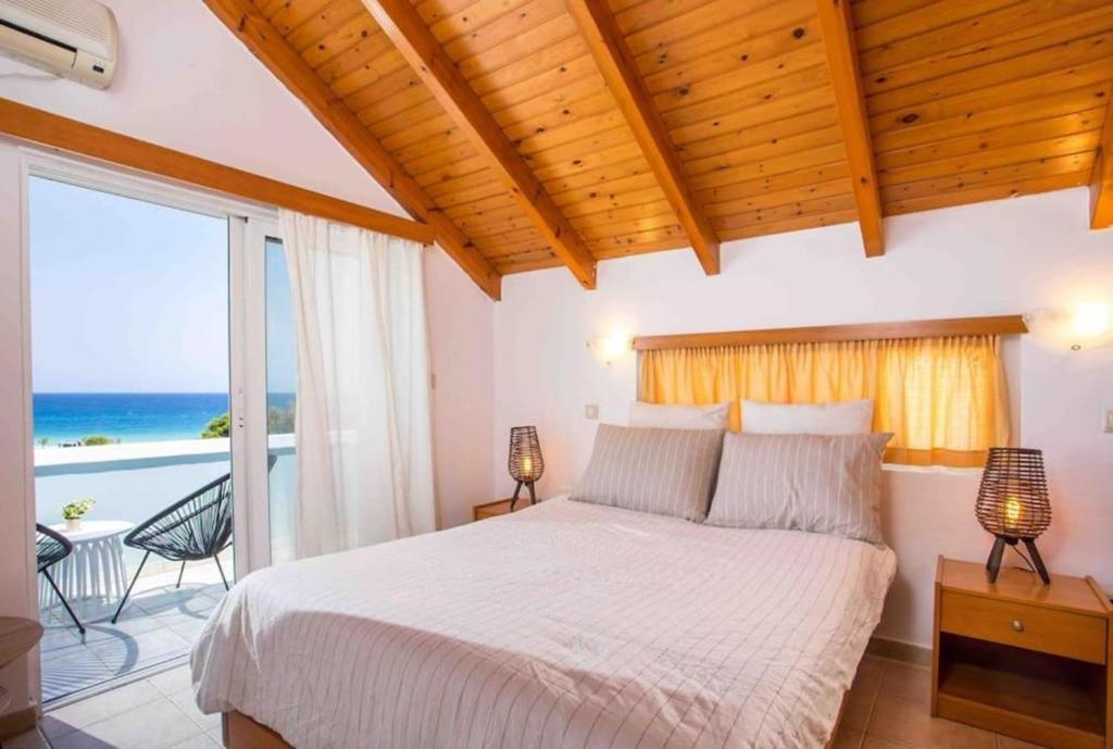 una camera da letto con un letto con vista sull'oceano di MEGAT SEAVIEW AND SEASIDE APARTMENTs a Ialyssos