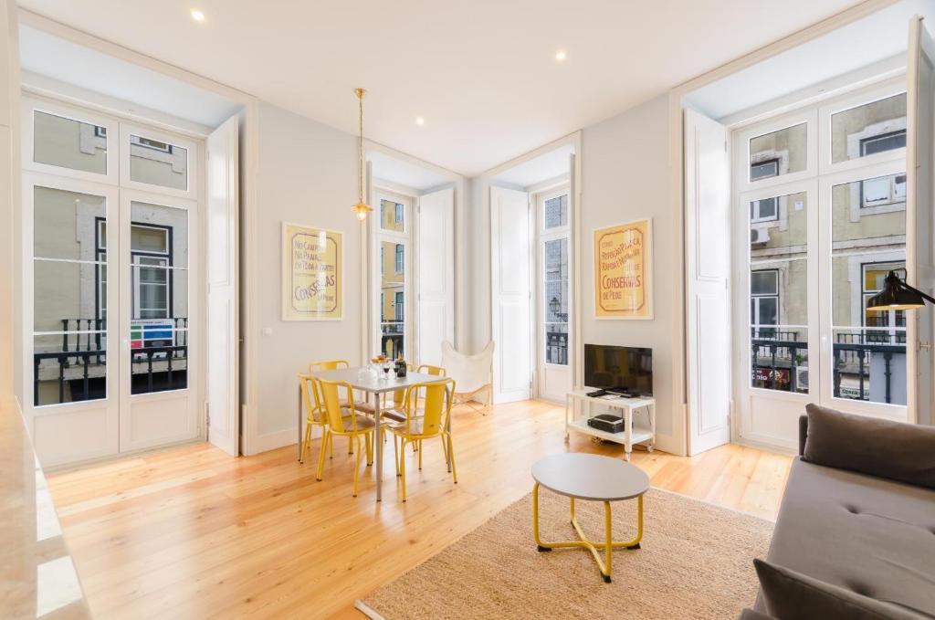 ein Wohnzimmer mit Tisch und Stühlen in der Unterkunft Residencial Neves - Baixa in Lissabon