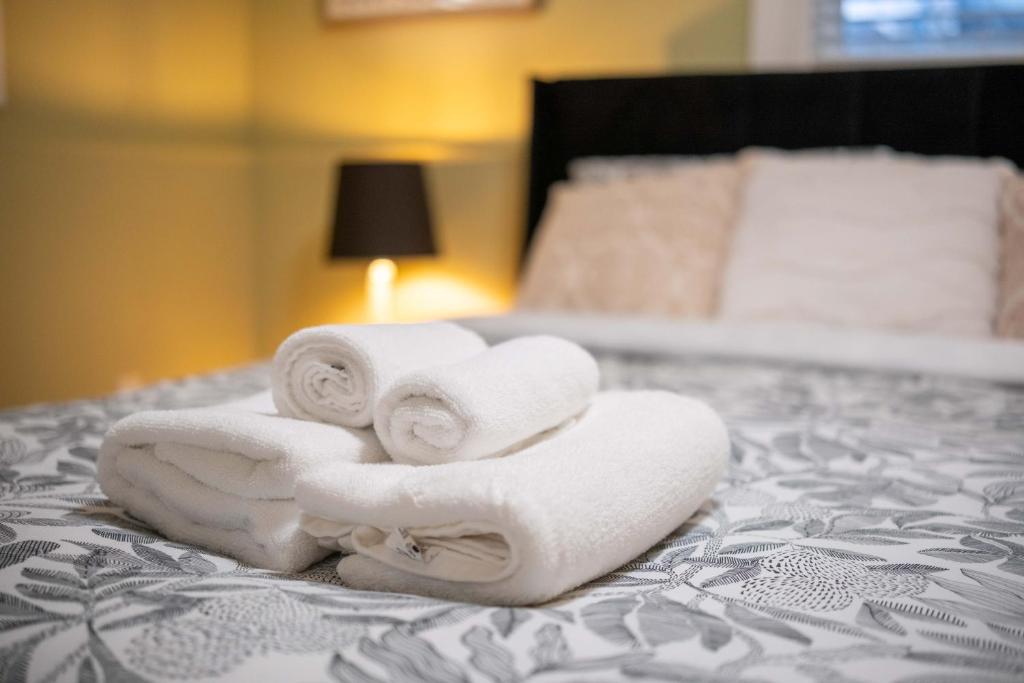 een stapel handdoeken bovenop een bed bij 2BR Trafalgar Retreat near UBC & Pacific Spirit in Vancouver