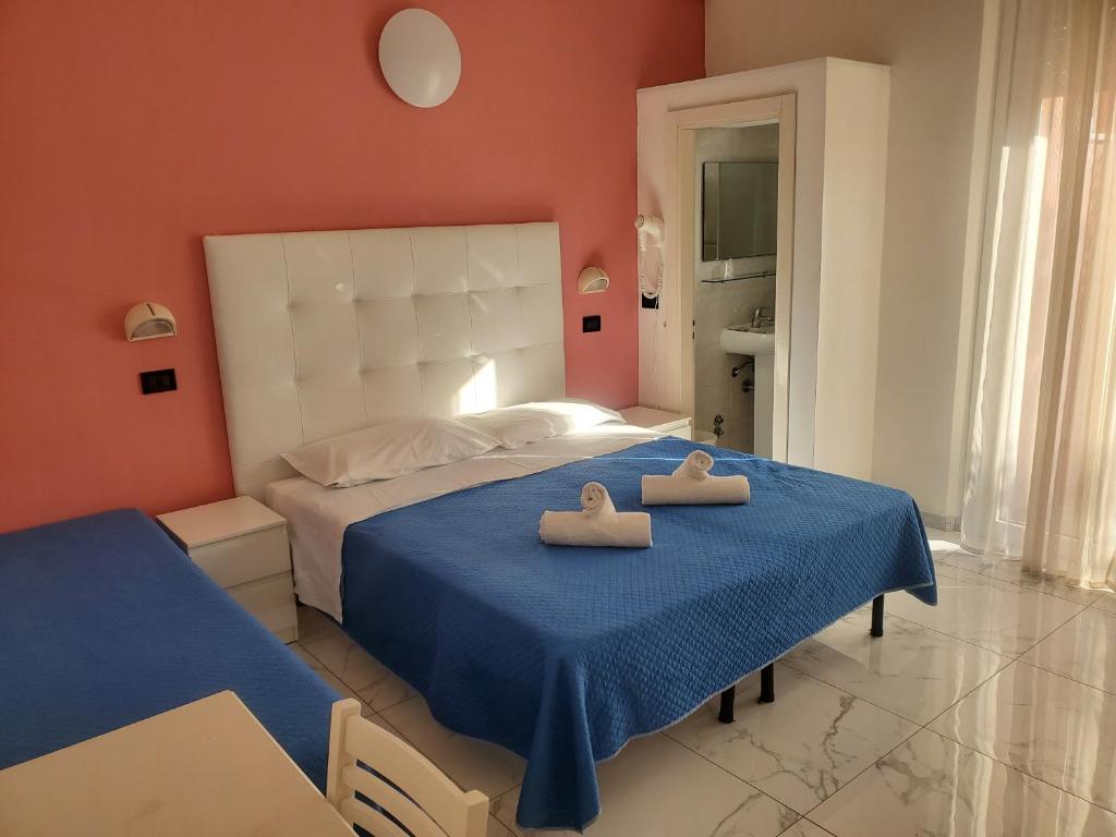 una camera da letto con un letto con due asciugamani sopra di HOTEL VILLA ELISA a Rimini