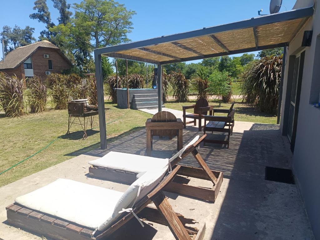 eine Terrasse mit 2 Liegestühlen und einem Tisch in der Unterkunft Retiro San Francisco 2 hasta 6 huespedes -Pais Uruguay in Paysandú