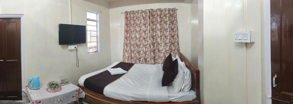 ein Schlafzimmer mit einem Bett mit einem Vorhang und einem Fenster in der Unterkunft Rumdali Homestay NX in Darjeeling