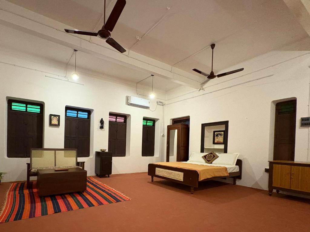 a bedroom with a bed in a room with windows at Ekantham Heritage Homestay in Tiruchirappalli