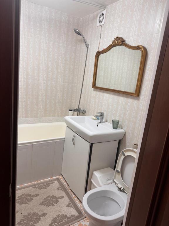 a bathroom with a toilet and a sink and a mirror at Квартира in Chişinău