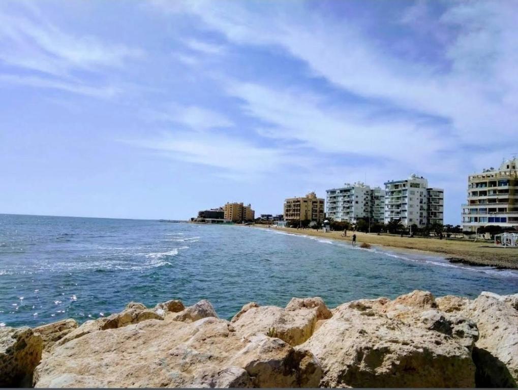 een uitzicht op een strand met gebouwen en de oceaan bij Marble Coast Studio Apartment in Larnaka