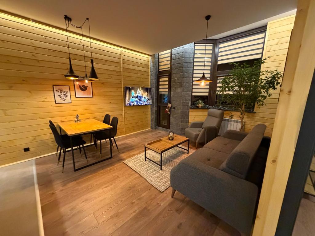 a living room with a couch and a table at Flora Hotel Apartment 103 in Borovets