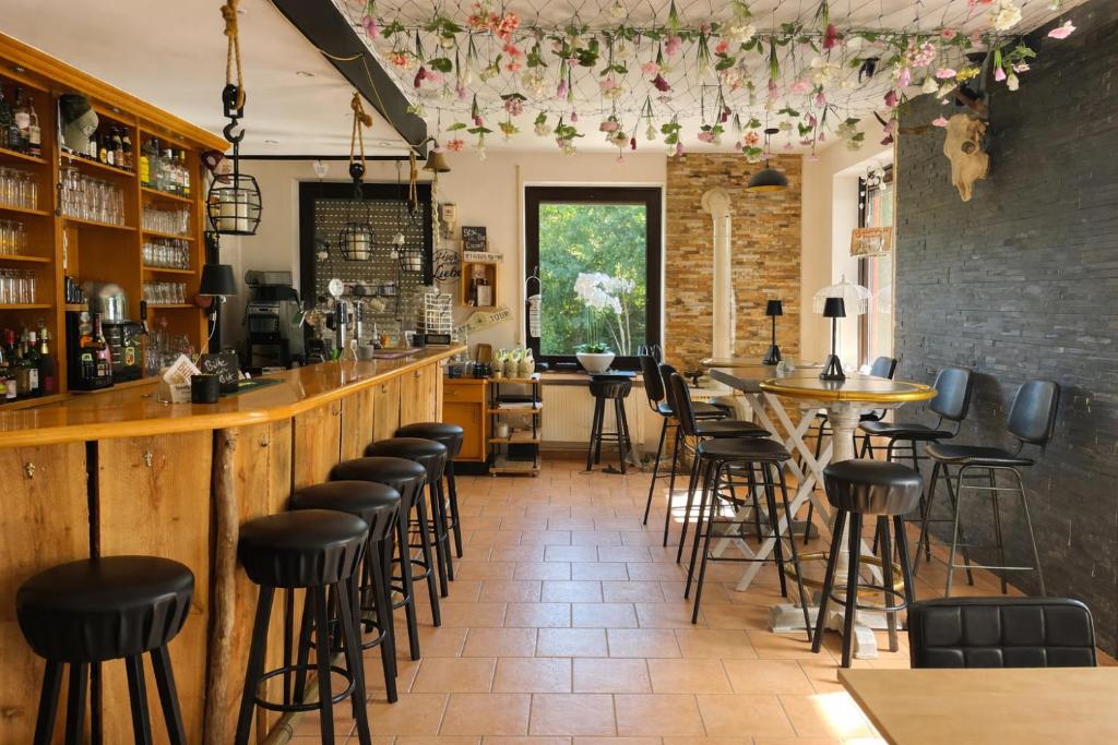 un bar avec des tabourets noirs dans un restaurant dans l'établissement Pension zur Quelle, à Deudesfeld