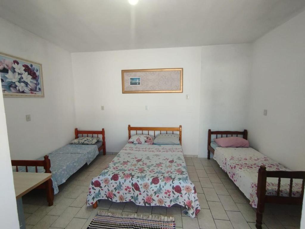 - une chambre avec 2 lits et une table dans l'établissement Suite Penha SC, à Penha