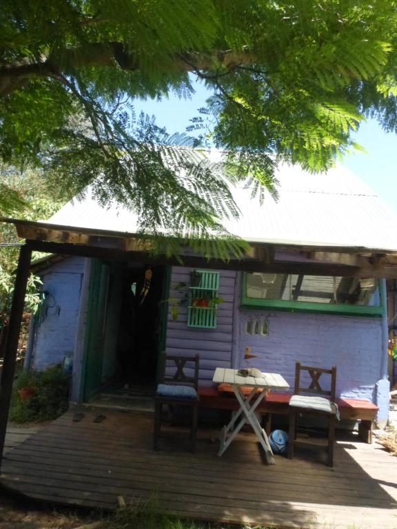 a house with a porch with a bench and a table at la remansa in Neptunia