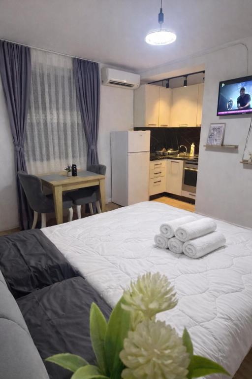 a bedroom with a white bed with towels on it at Krid Tirana Studio Flat in Tirana