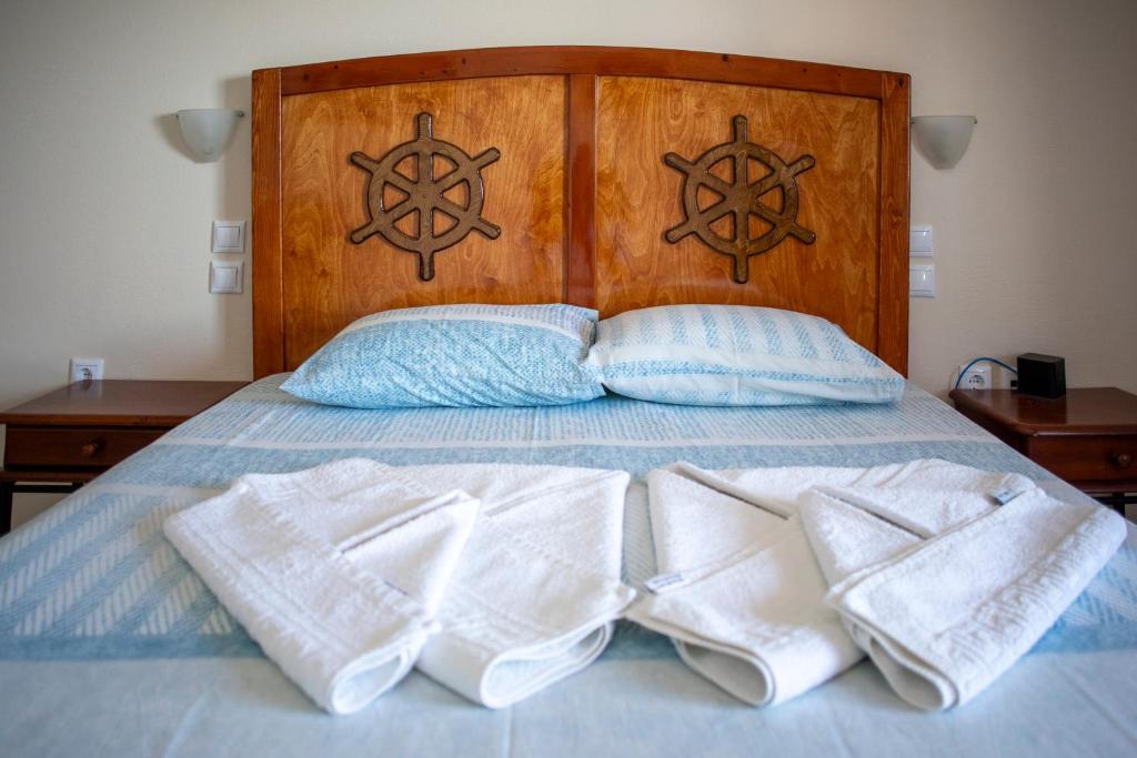 a bed with two towels and two pillows on it at TO VOTSALO-beach side studios & taverna in Karpathos