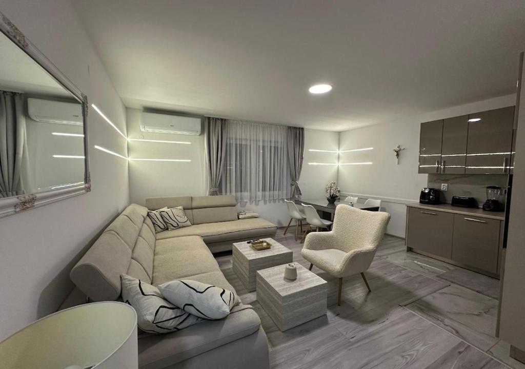 een woonkamer met een bank en stoelen en een keuken bij Centar Posušje Jednosobni stan in Posušje