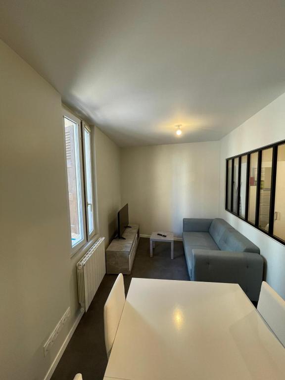 ein Wohnzimmer mit Sofa und Tisch in der Unterkunft Apartment with terrace and barbecue Hyper center in Mâcon