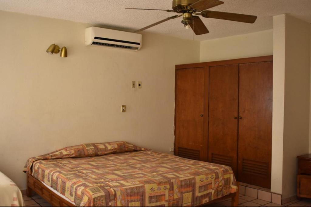 a bedroom with a bed and a ceiling fan at Suites Menavi in Acapulco