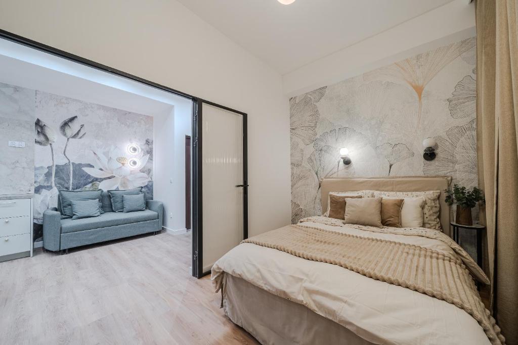 een slaapkamer met een groot bed en een blauwe bank bij Złota 7 Apartment in Warschau