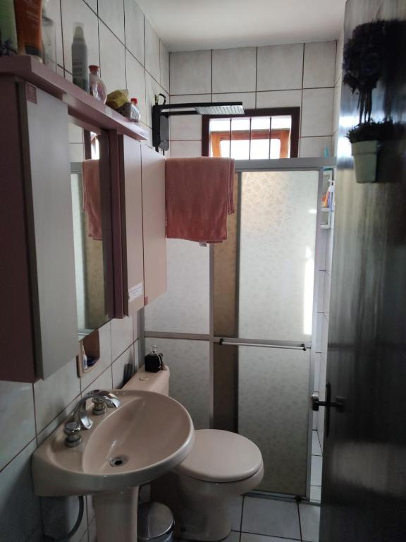 a bathroom with a sink and a toilet and a shower at Família Jardim in São Gabriel