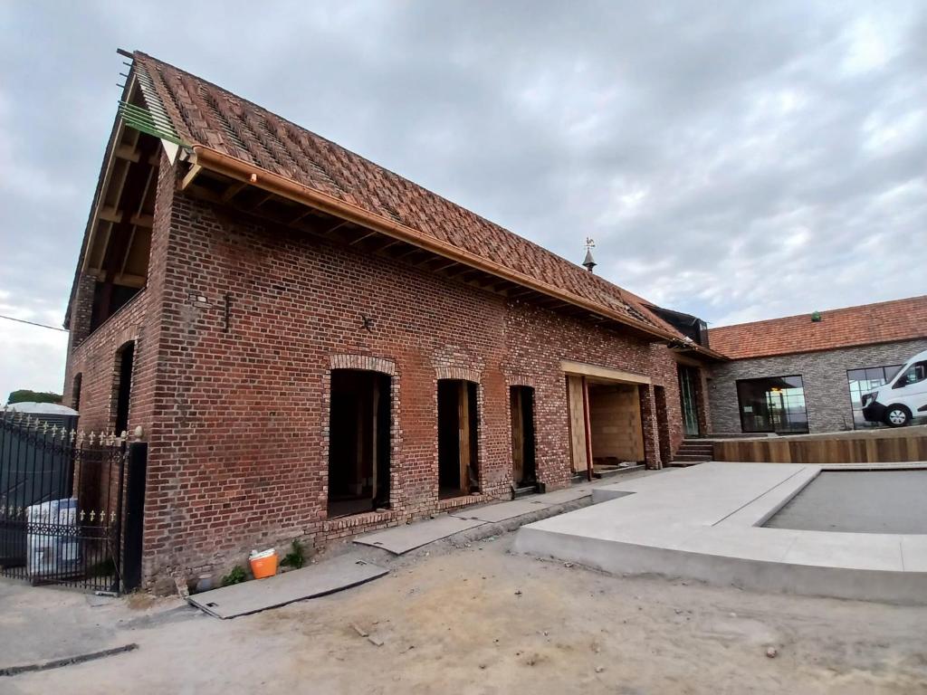 a brick building with a parking lot in front of it at Tjusteplekske in Heuvelland