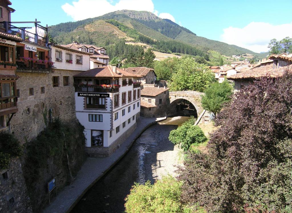 un puente sobre un río en una ciudad con edificios en Apartamento El Nial de Potes, en Potes