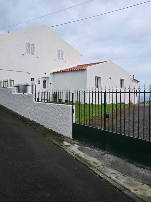 una recinzione di fronte a un edificio bianco di Rustica Ocean View House a Bretanha