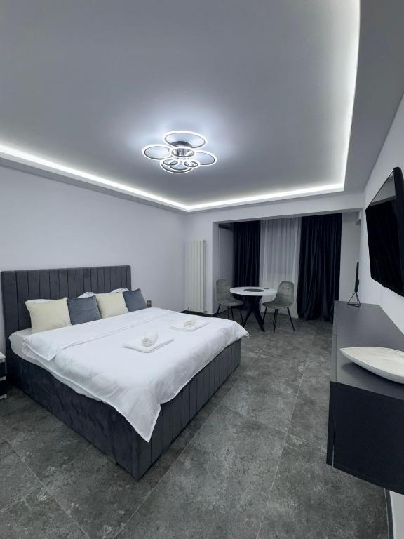 a bedroom with a large bed and a table at Grey Serenity in Brăila