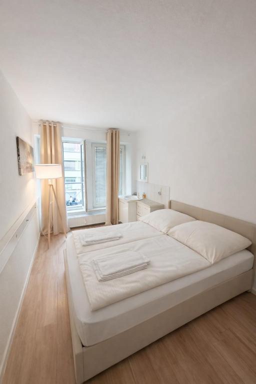 a large white bed in a room with a window at Munich Premium Guesthouse in Munich