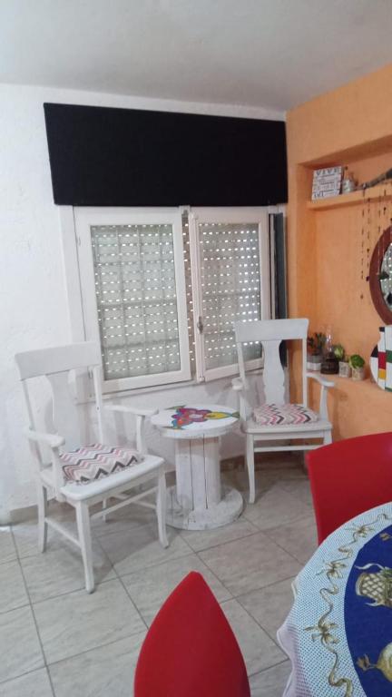 ein Wohnzimmer mit weißen Stühlen und einem Tisch in der Unterkunft La casita in Villa Santa Cruz del Lago