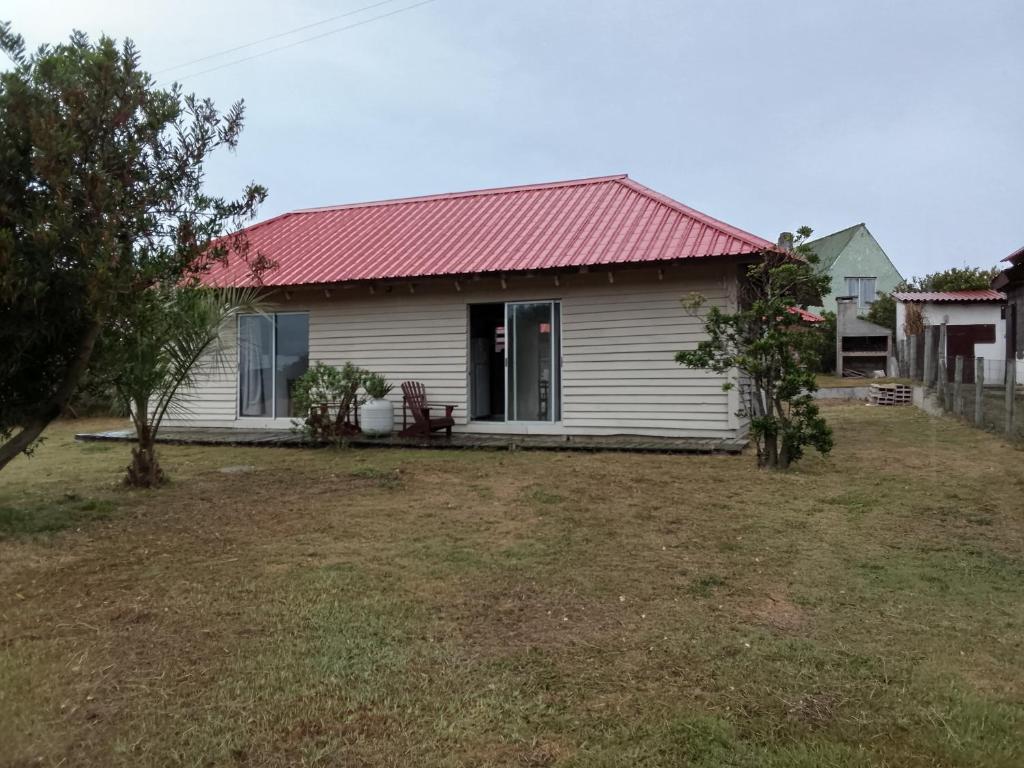 una piccola casa bianca con tetto rosso di Palafito ad Aguas Dulces