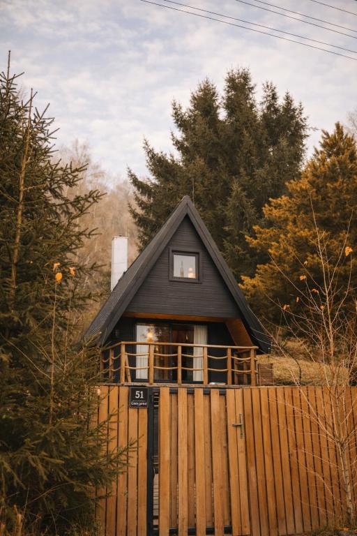 a small house with a fence in front of it at The Nest - Sauna and Hot Tub in Rynoltice