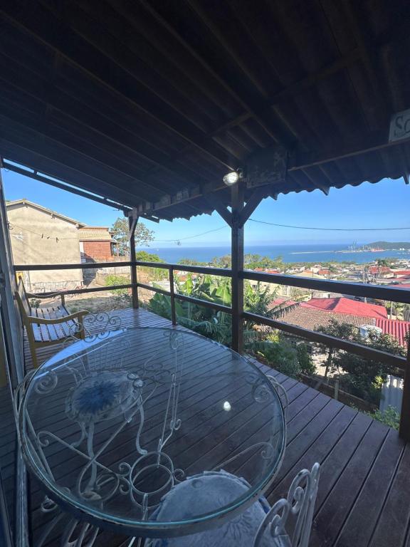 a table on a deck with a view of the ocean at Container Porto Alvorada in Imbituba