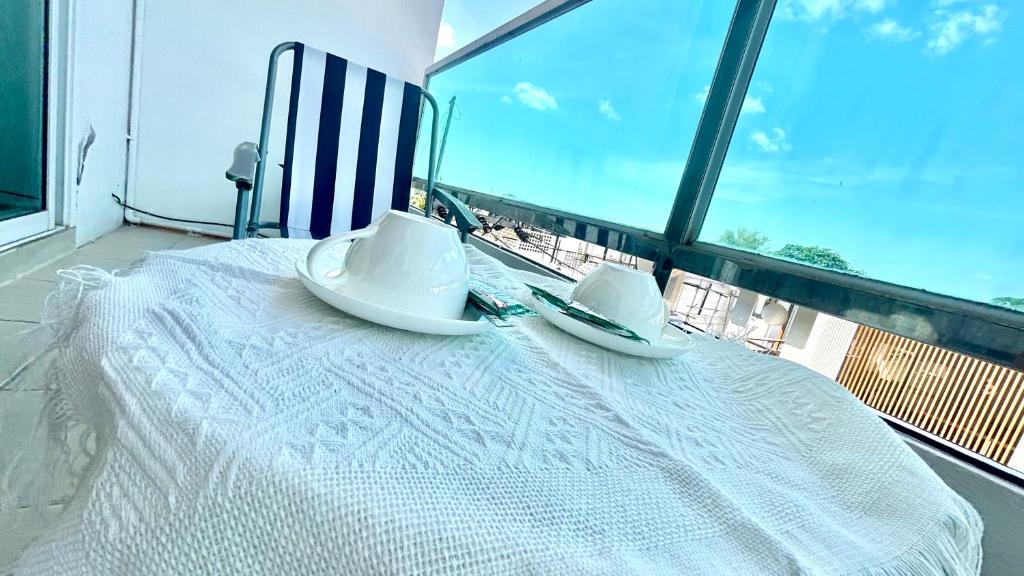 een tafel met twee witte borden op een balkon bij The Sunset Bangsaen in Ban Rong Khoei