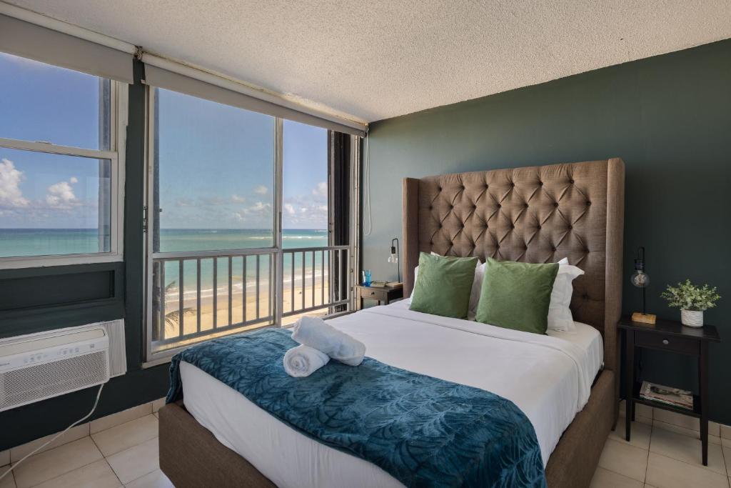 una camera da letto con un letto con vista sull'oceano di Punta Arenas 1BDR Oceanfront Pool Parking a San Juan