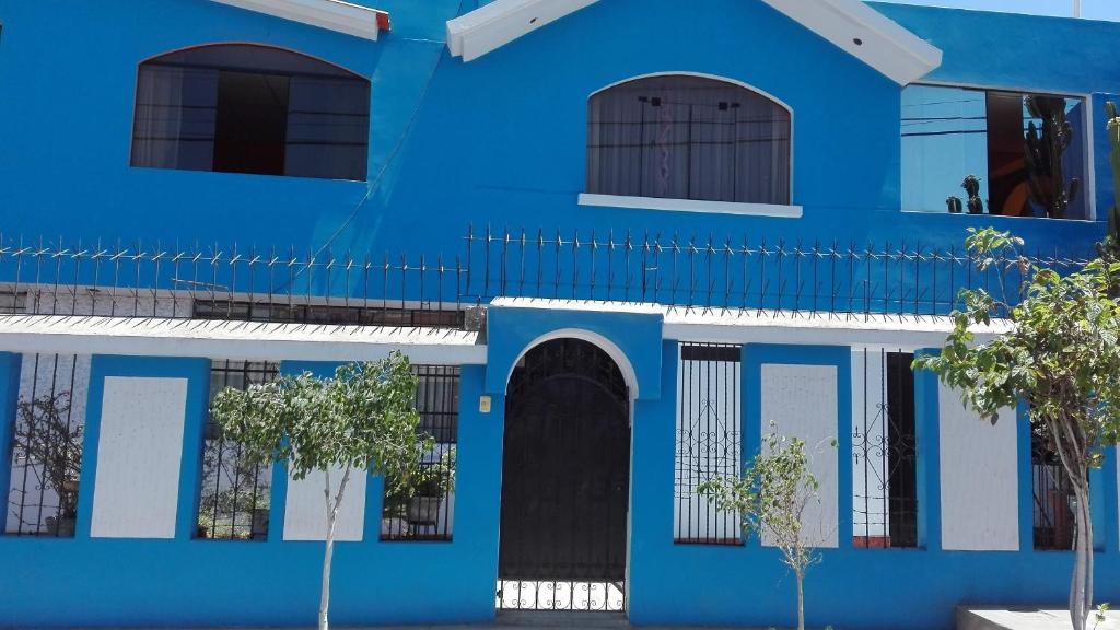 un edificio azul y blanco con árboles delante en Ramirez House, en Arequipa