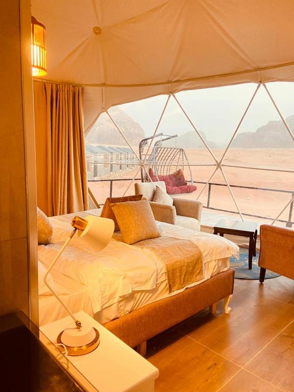 a bedroom with a bed with a view of a boat at Sunrise Luxury Camp in Wadi Rum