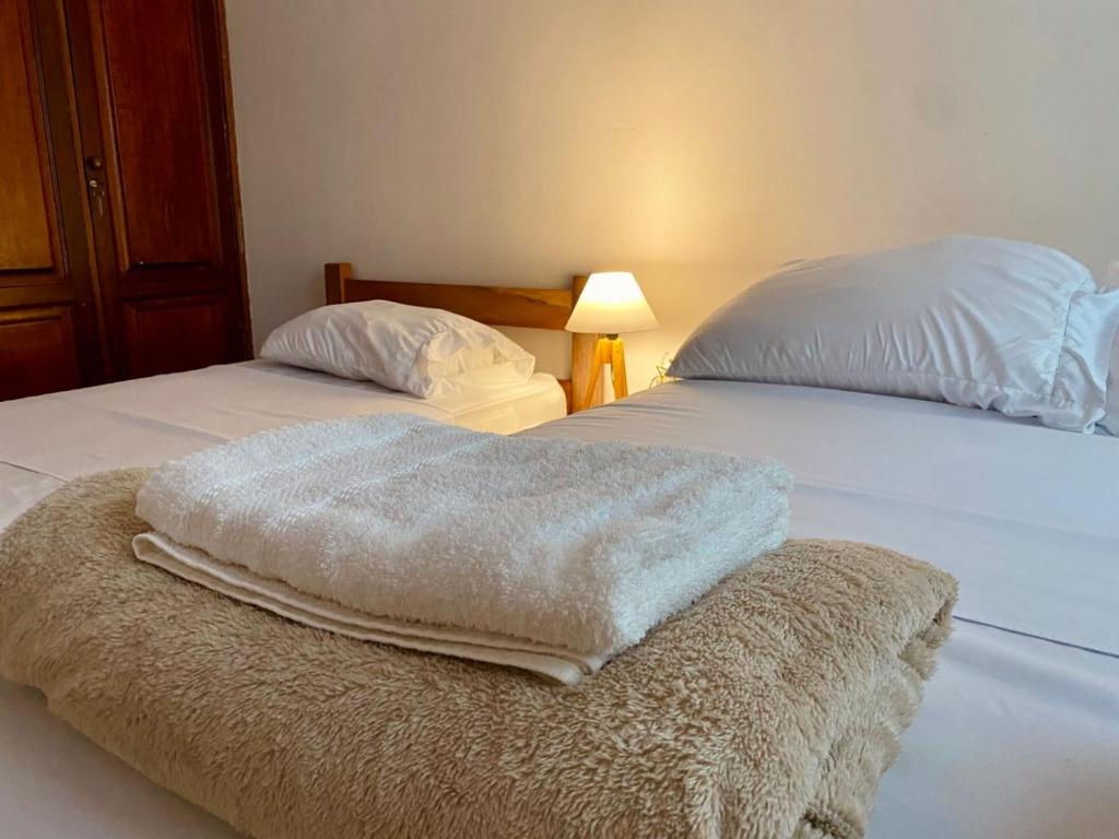 贝伦Casa Miriti Hostel - a 200m da Basílica de Nazaré的两张带白色床单和枕头的床