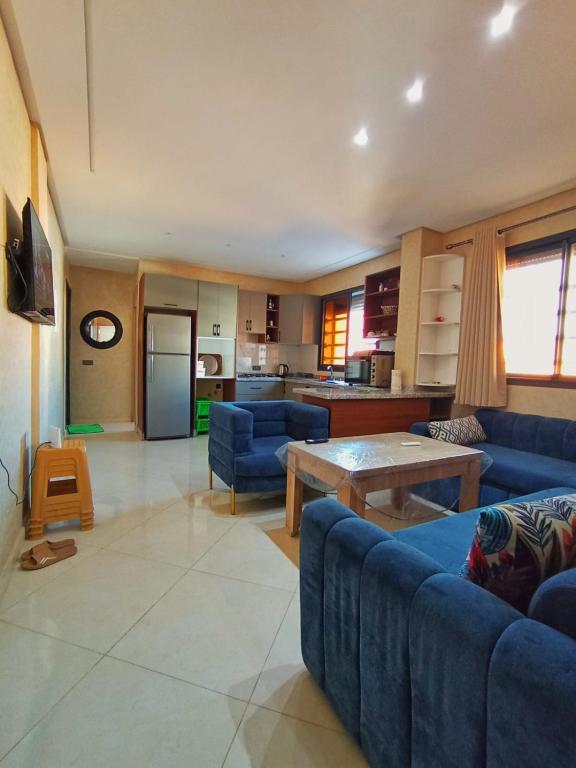 a living room with blue couches and a table at Blue Wave Surf House in Mirleft