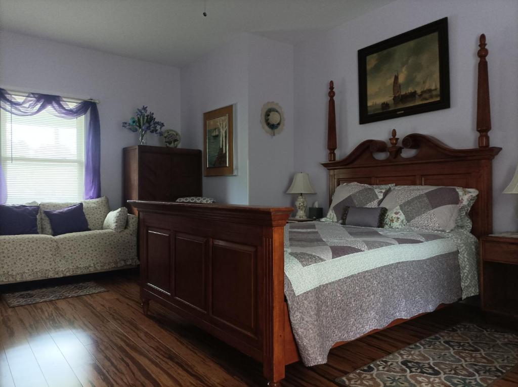 a bedroom with a bed and a couch at Cantuta Inn in Harpers Ferry