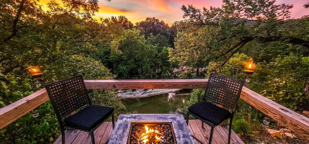 twee stoelen op een terras met een vuurplaats bij Cliffside Cabin at Piney Falls - with Creek Access 